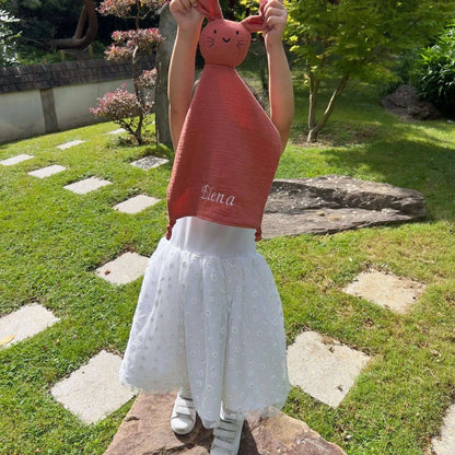 Enfant tenant un doudou personnalisé terracotta brodé au prénom Elena